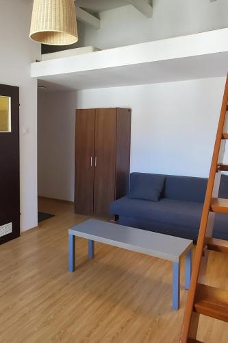 a living room with a blue couch and a ladder at Take a rest in the center of Krakow, Zyblikiewicza in Kraków