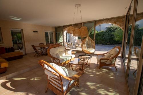 - un salon avec des chaises, une table et un miroir dans l'établissement Charmante villa avec piscine proche ville et plage, à Calvi