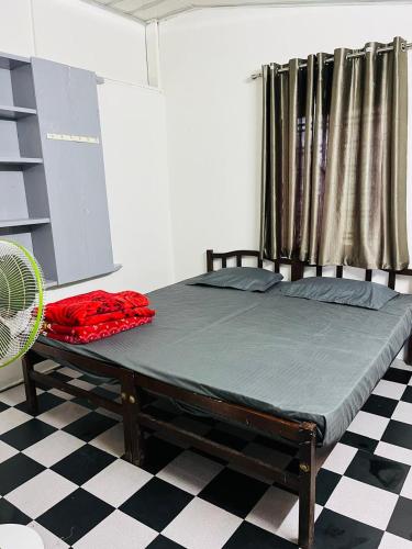 a bed sitting in a room with a fan at GreenSpot Homestay in Idukki
