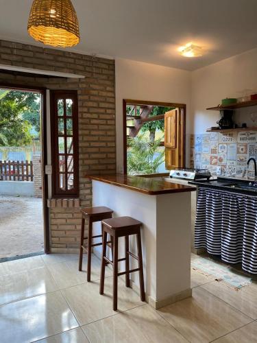 ポルト・デ・ガリーニャスにあるKailua apartamentos e suítesのキッチン(カウンター、スツール2つ付)