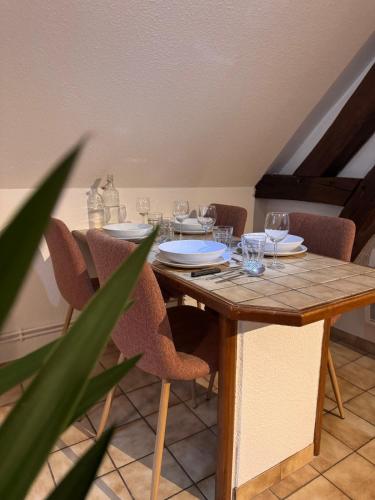 - une table en bois avec des chaises et des verres à vin dans l'établissement L'Atelier - Logis d'artiste - Centre historique, à Troyes