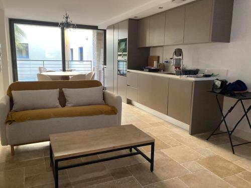 un salon avec un canapé et une cuisine dans l'établissement Les ISSAMBRES, à Roquebrune-sur Argens