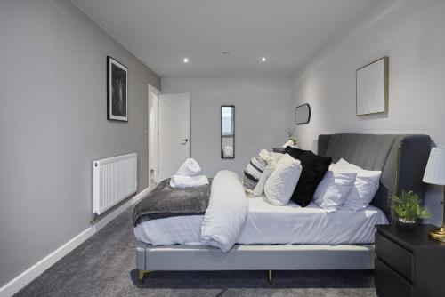 a bedroom with a bed with pillows on it at Hayy Luxury Homes Near Bradford City Centre in Bradford