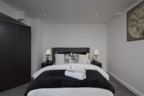 a bedroom with a large bed with two towels on it at Hayy Luxury Homes Near Bradford City Centre in Bradford