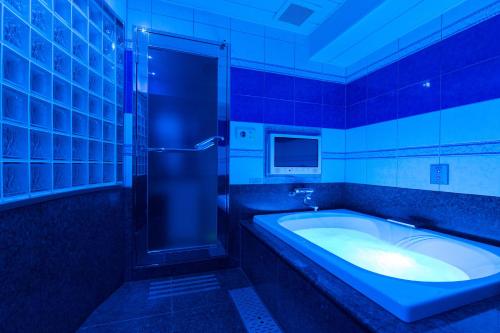 a bathroom with a tub and a shower and a television at HOTEL & SPA J-MEX Shinjuku Kabukicho (Adult Only) in Tokyo