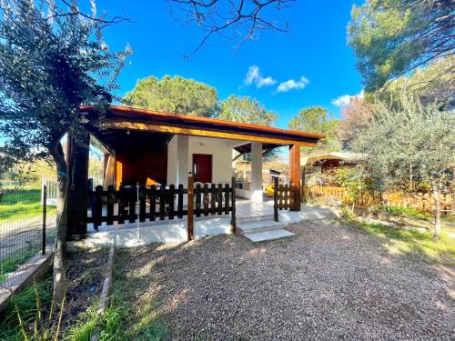 a small house with a wooden fence around it at Sea Breeze Home in Lotzorai