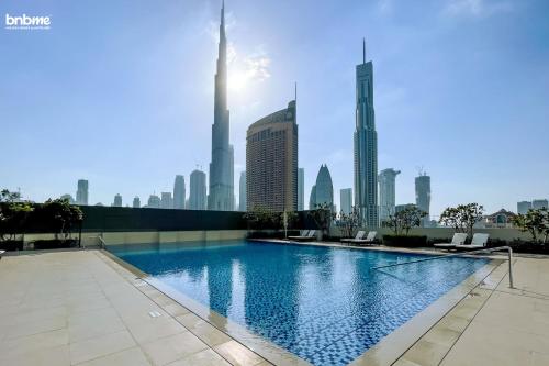 a swimming pool with a city skyline in the background at bnbmehomes - Downtown Views II - Tower 1 in Dubai