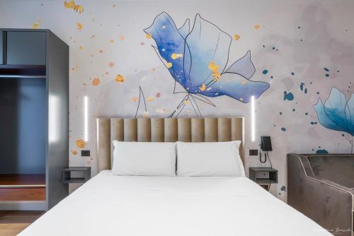a bedroom with a large bed with a blue umbrella at Hotel Adamas in Florence