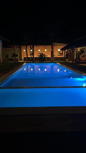 a swimming pool with blue lighting at night at Pousada Vila Flow in Cumbuco