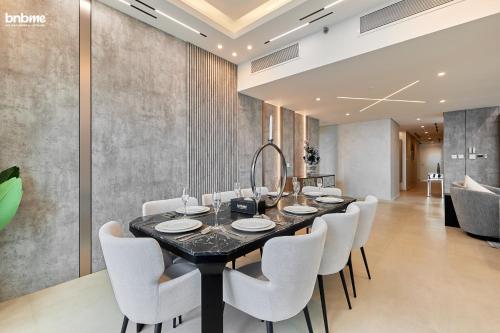 a dining room with a black table and white chairs at bnbmehomes - Downtown Views II - Tower 1 in Dubai