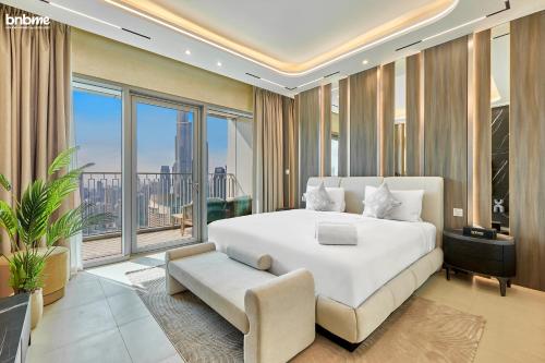 a bedroom with a white bed and a large window at bnbmehomes - Downtown Views II - Tower 1 in Dubai