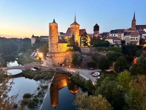un château avec des tours et un pont sur une rivière dans l'établissement Appartement "STADTGEFLÜSTER" im Zentrum, inkl Stellplatz, 2 Betten, Babybett, Balkon, gratis Kaffee und Tee, WLAN, à Bautzen