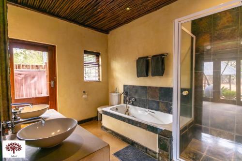 a bathroom with two sinks and a tub and a shower at Zebula Golf and Wildlife Estate - Moi Signature Exclusive Leisure Villas in Mabula