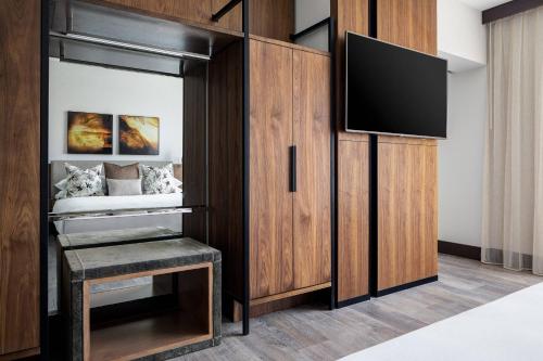 a bedroom with a bed and a tv on a wooden cabinet at Odessa Marriott Hotel & Conference Center in Odessa