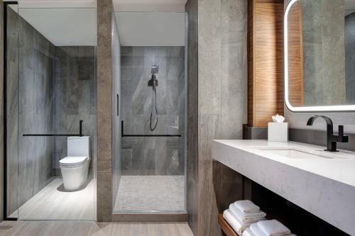 a bathroom with a shower and a toilet and a sink at Odessa Marriott Hotel & Conference Center in Odessa