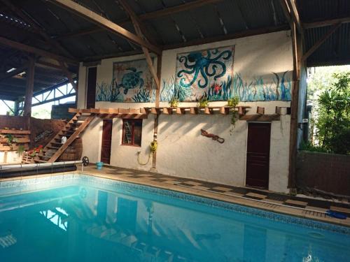 - une piscine dans une maison avec graffiti sur le mur dans l'établissement Gîte de la Chenardais, à La Boussac