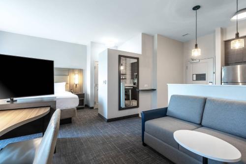 a hotel room with a bed and a couch and a tv at Residence Inn by Marriott Anderson Clemson in Anderson