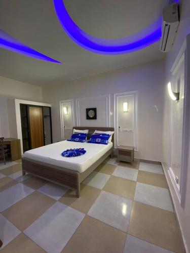 a bedroom with a bed with blue pillows on it at Furnished studio 15 year old plateau in Motsouémbé