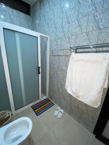 a bathroom with a toilet and a sink and a towel at Furnished studio 15 year old plateau in Motsouémbé