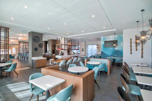 マイアミにあるTownePlace Suites by Marriott Miami Airportのテーブルと椅子のあるレストランとカフェテリア
