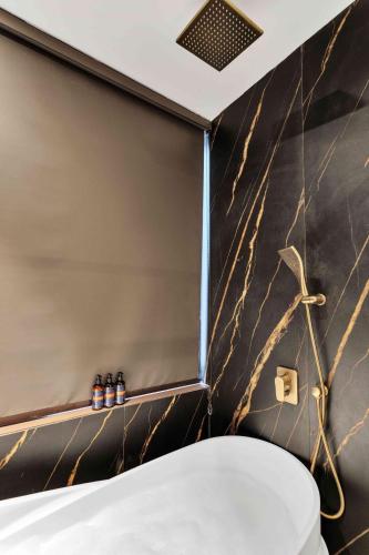 a bathroom with a black and gold wall at Vilasa 5 BHK by tisyastays in Vagator