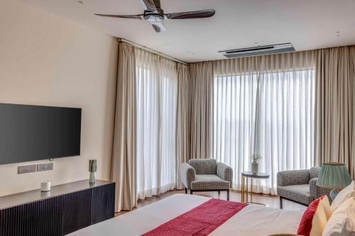 a hotel room with a bed and a flat screen tv at Vilasa 5 BHK by tisyastays in Vagator