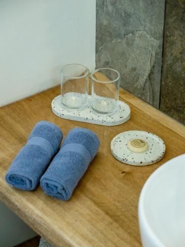 a wooden table with two glasses and towels on it at Villa design avec piscine privée à El Nido in El Nido