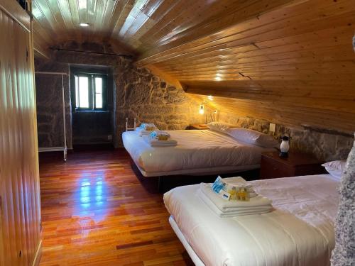a room with two beds in a log cabin at A casiña do abuelo Pepe in A Lama