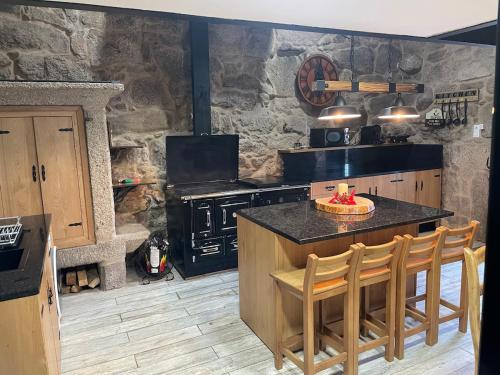 a kitchen with a stove and a table with chairs at A casiña do abuelo Pepe in A Lama