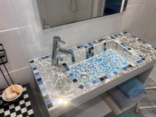 a bathroom with a sink with a glass counter top at Wonderland Rooms in Petit-Bourg