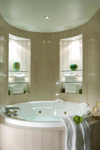 a white bath tub in a bathroom with towels at Sydney Harbour Marriott Hotel at Circular Quay in Sydney
