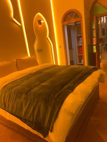 a bedroom with a bed with a chair in it at Vintage Green House in Fez