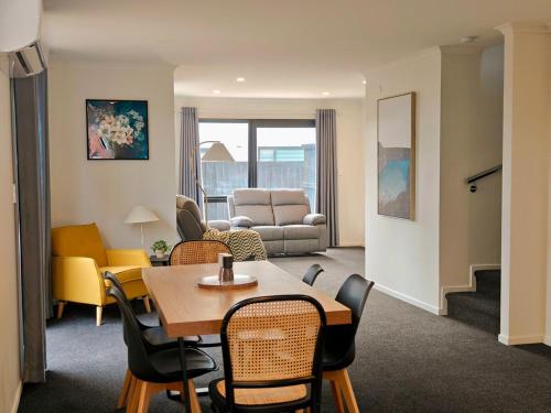 a living room with a table and chairs and a couch at Modern Comfort in Hillcrest in Hamilton