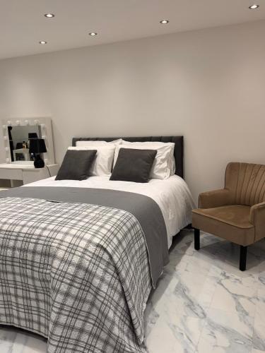 a bedroom with a bed and a chair at Modern House Apartment Stratford E15 London - Sleeps 2 - 9, Fast Links to Central London, Near O2, Greenwich & Olympic Park, Child-Friendly Garden, Free Parking, Free WiFi in London
