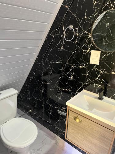 ポルト・ベロにあるPousada Nosso Bosqueの白いトイレと洗面台のあるバスルーム