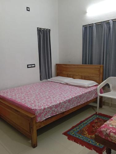 a bedroom with a bed with a wooden frame at Blessing Homestay in Pūvār