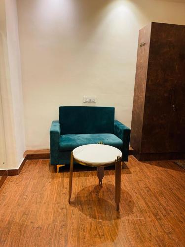 a living room with a blue couch and a table at The Taaj Comforts in Bengaluru