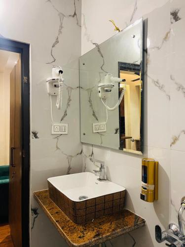 a bathroom with a sink and a mirror at The Taaj Comforts in Bengaluru