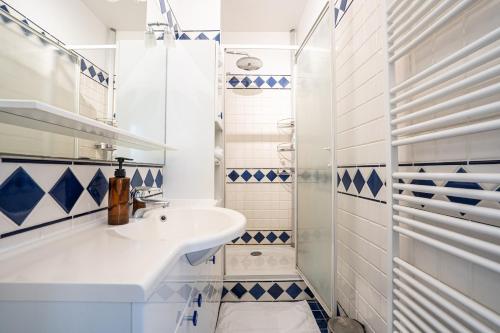 une salle de bain blanche avec un lavabo et une douche dans l'établissement Appartement Lumineux avec balcon proche paris - II, à Boulogne-Billancourt