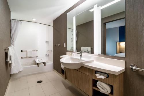 a bathroom with a sink and a tub and a mirror at SpringHill Suites By Marriott Charleston Airport & Convention Center in Charleston