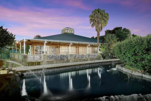 a house with a pond in front of it at Protea Hotel by Marriott Klerksdorp in Klerksdorp