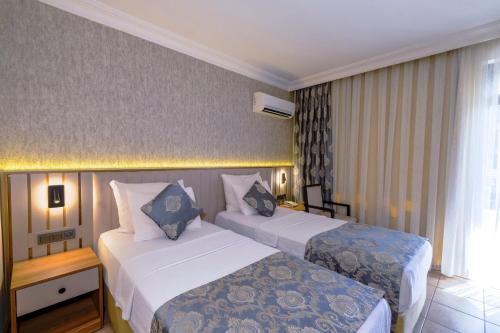 a hotel room with two beds and a window at Kandelor Hotel in Alanya