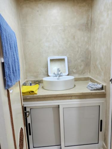 a bathroom with a sink and a blue towel at Quadra Sphere in Tamraght Ouzdar