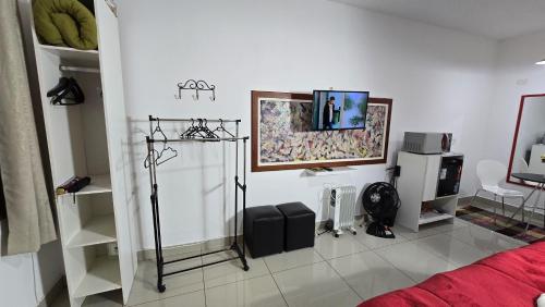 a room with a bed and a tv on the wall at Apto Girassol in Monte Verde