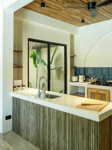 a kitchen with a sink and a large window at Villa design avec piscine privée à El Nido in El Nido
