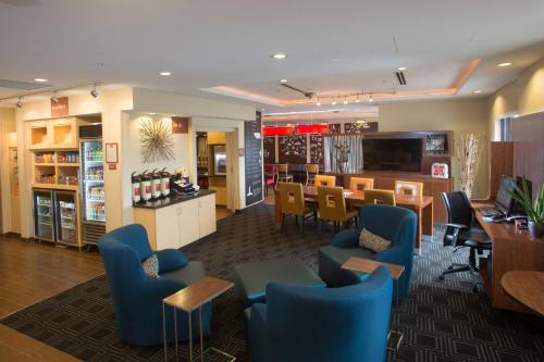 a restaurant with blue chairs and a dining room at TownePlace Suites by Marriott Lincoln North in Lincoln
