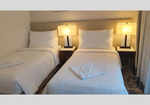 a hotel room with two beds and two lamps at Address Beach Resort Fujairah - Apartments in Fujairah