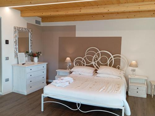 a bedroom with a large white bed and a wooden ceiling at Ca' Baetti l'Antica Corte in Roncola