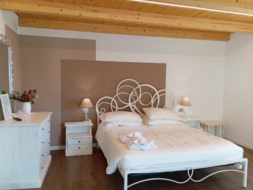 a bedroom with a white bed and a wooden ceiling at Ca' Baetti l'Antica Corte in Roncola