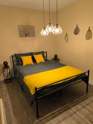 une chambre avec un lit avec des oreillers jaunes dans l'établissement Le Logis dans la place appartement de deux chambres, à Thouarcé